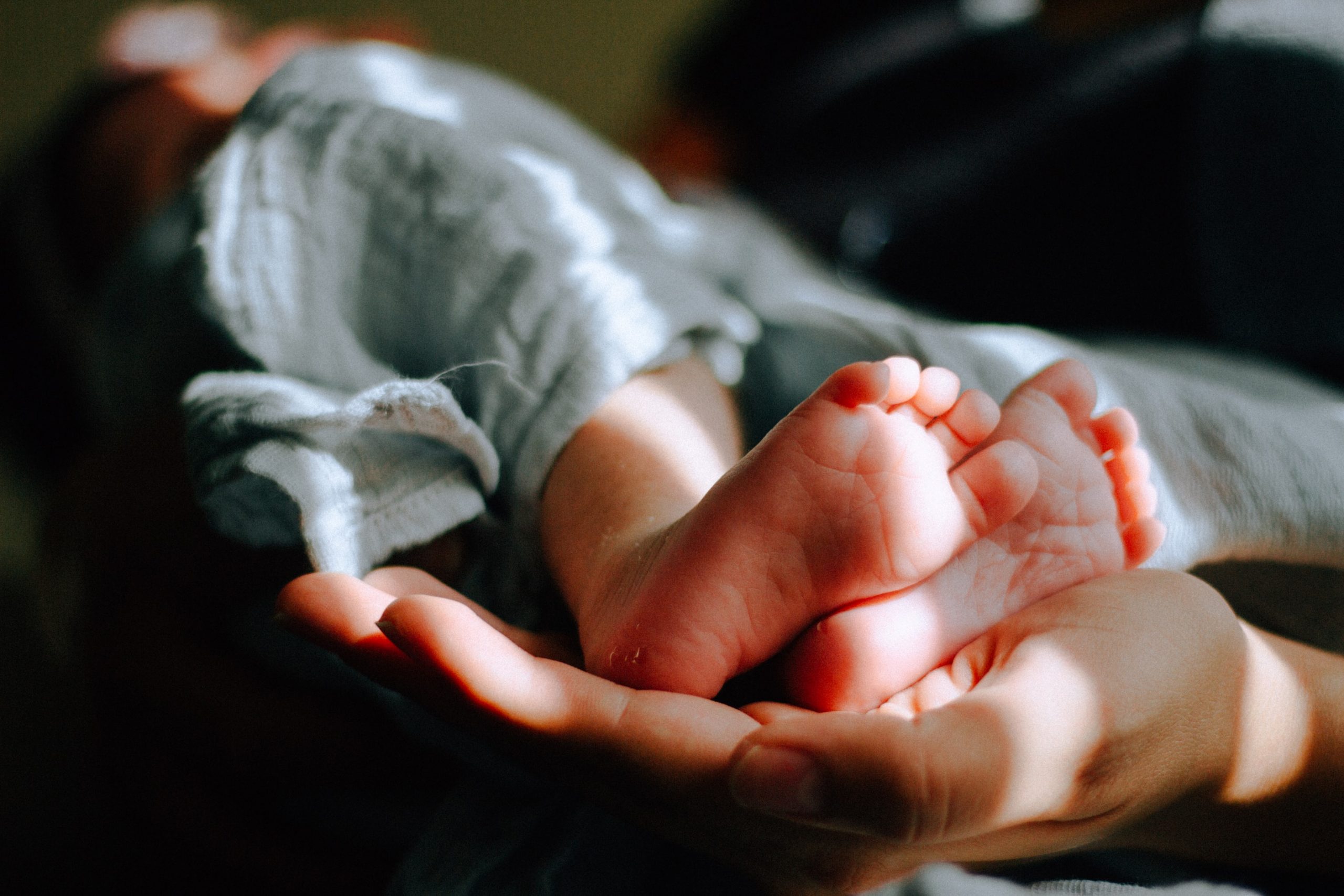 Baby's feet on mom's hand